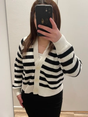 Svartvit randig kofta – i mycket fint skick  - Säljer en stilren och trendig randig kofta i mjukt stickat material. Perfekt basplagg som är lätt att matcha med både jeans, kjol och klänning – funkar till både vardag och finare tillfällen. Den är köpt från barnavdelningen på Lindex i storlek 146-152.  Knappt använd och i mycket bra skick, inga fläckar eller skador. Bekväm passform med knappar framtill🤍🖤