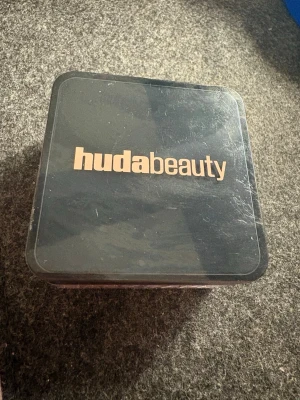 Huda Beauty Easy Bake Duo Pink Pumpkin - Huda Beauty Easy Bake Duo i färgen Pink Pumpkin (Pink Velvet Cookie/Pumpkin Pie). Detta är ett löspuder i två nyanser, perfekt för att fixera sminket och ge en jämn finish. Kommer i en kompakt, fyrkantig förpackning i svart plast.