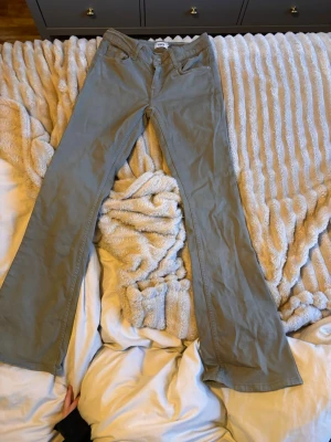 Khakigröna bootcut jeans 157 - Säljer ett par khakigröna jeans från 157 med bootcut-modell. Jeansen har klassiska fem fickor och är tillverkade i ett mjukt bomullstyg. Perfekta för dig som gillar en avslappnad men ändå trendig look.