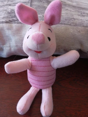 Nalle Puhs Nasse gosedjur rosa - Söt mjukisdjur i form av Nasse från Nalle Puh, ca 18 cm hög. Tillverkad i mjuk rosa plysch med broderade detaljer och randig mage. Perfekt som present eller dekoration för fans av Disney och klassiska barnfigurer.