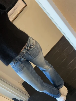Lågmidjade jeans - Midja: ca 38 cm. Innebenslängd: ca 78 cm. Toppen skick utöver små slitningar längst ner samt en liten fläck, Se bilder. Säljer även andra lågmidjade jeans i min profil