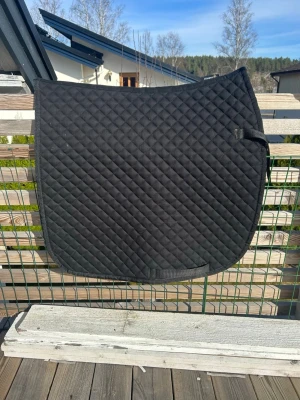 Svart schabrak till häst - Säljer ett svart, rutmönstrat schabrak till häst. Schabraket är i dressyr form. Ligger fint och bra på ryggen.