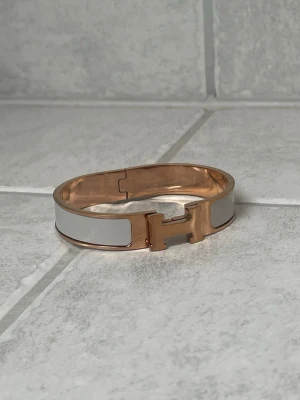 H armband - Snyggt armband i färgerna grå och rose gold. Armbandet är i mycket bra skick. Tyvärr finns det inga tillbehör 