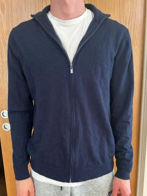 Mörkblå full ziptröja från Lawrence Grey - Mörkblå ziptröja från Lawrence Grey i 100% merinoull. Tröjan är i storlek M och har en skön och fin passform samt är i strålande skick. Nypris är ca 1000 