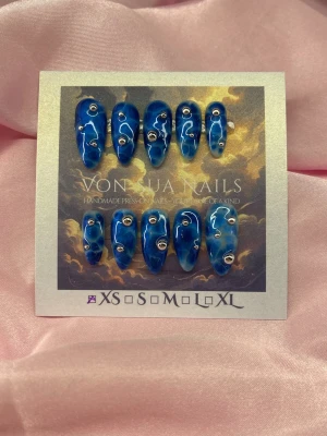Swim (XS);Medium Almond - Unika handgjorda press-on naglar i en djup blå färg med hav effekt. Naglarna har en medium längd och almondform och är dekorerade med silvriga pärlor, för en cool och trendig look. Perfekt för dig som vill sticka ut.XS: 14 mm, 11 mm, 11,5 mm, 10 mm, 8 mm 