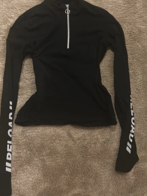 Svart långärmad topp från FB Sister - Svart långärmad topp från FB sister. Tight passform och hög krage ger en sportig vibe. 