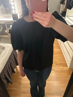 Svart satintopp - Svart satintopp med puffärm. Använd fåtal gånger men är lite sliten uppe runt kragen (se sista bilden)