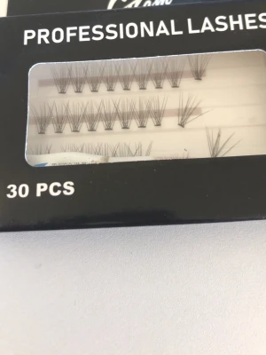 Professional Lashes 30-pack - Ett set med 30 individuella lösögonfransar från Glam of Sweden. Fransarna är svarta, tunna och i olika längder för en naturlig look. Perfekta för att bygga volym och anpassa efter önskad stil. Förpackningen är svart med genomskinligt fönster. ( man får med ett ögonfrans lim från duo men det är lite andvänd) 