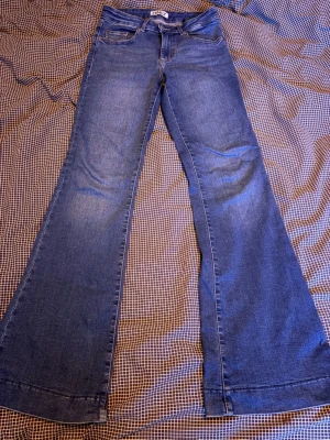 Blå utsvängda jeans från ONLY - Säljer ett par blå jeans från ONLY med riktigt snygg utsvängd passform och mid waist. Jeansen är gjorda i mjukt denimtyg och passar till allt.