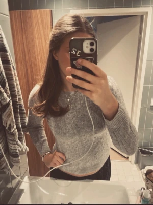 Grå cashmere tröja från Davida - Säljer en grå kabelstickad tröja från Davida i storlek M. Tröjan är gjord av mjuk cashmere och har rund halsringning samt ribbade muddar. Perfekt för att hålla sig varm och snygg under kyliga dagar😊😊