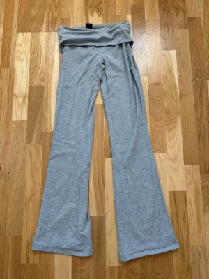 Grå mjukisbyxor från Gina Tricot - Snygga grå yogapants från Gina Tricot💗 är foldover pants så ska vikas dubbelt som visas på bild, byxorna är i storlek S och är knappt använda. Inga skador längst ner på byxbenen som visas på bild 3☺️