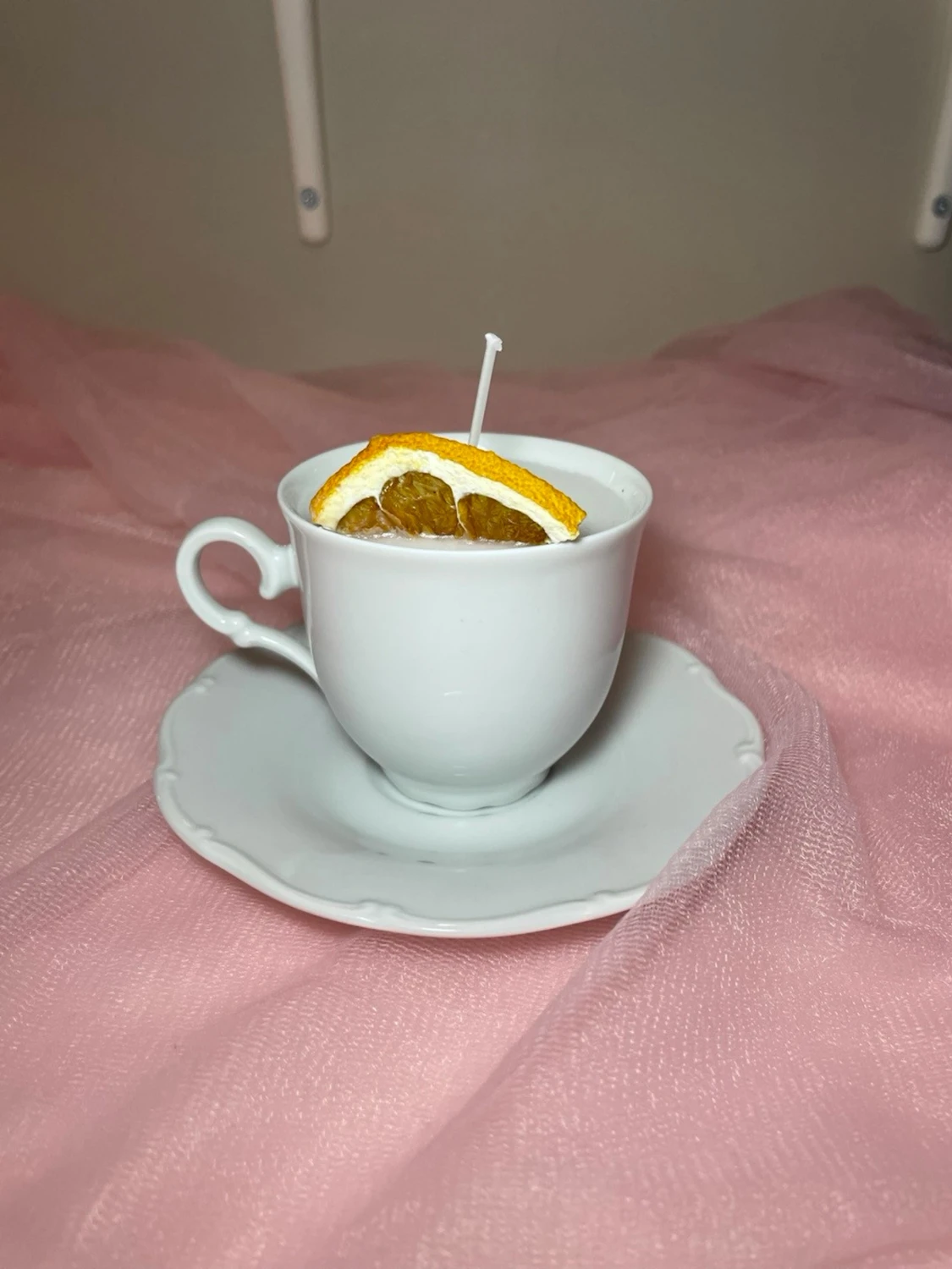 Doftljus med vaniljdoft i en vit tekopp 