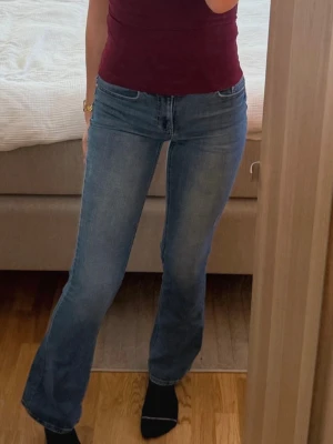 Blå bootcut jeans - S/34 - Snygga bootcut/utsvängda jeans från Vero Moda i en klassisk mellanblå tvätt. Figurnära upptill med lätt utsvängda ben. Detaljer: • Storlek: S / längd 34 • Modell: Bootcut / utsvängda • Färg: Blå denim • Normal midja • Stretchigt och bekvämt material Skick: Mycket bra skick – enda skavanken är ett litet slitage över bakfickan. 