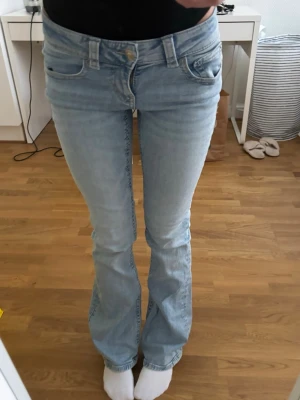 Ljusblå bootcut jeans från Ginatricot - Säljer ett par ljusblå lågmidjade bootcut jeans, från Gina tricot, midjemått: 33cm, innerbenslängd: 79cm, storlek 34 