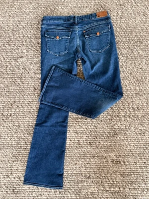 Låtmidjade bootcut jeans från & - Säljer ett par lågmidjade bootcut jeans från & (H&M’s tidigare jeansmärke från 00-talet). Dessa jeans är smått stretchiga och sätter sig snyggt över benen. Detaljerna på fickorna är väldigt fina och trendiga. De är av fin kvalitet och varsamt använda. Skulle uppskatta att storleken hör till S/M. Hör av dig för mer information eller fler bilder. 