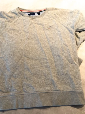 Grå stickad tröja från Gant - Ljusgrå sweatshirt från Gant i fint skick, den är i 146 - 152 eller M i barnstorlek. Hör bara av er vid funderingar, kan skickas inom en dag!