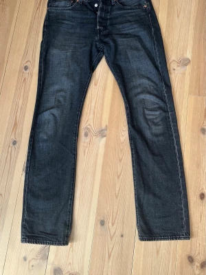 Svarta raka jeans från Levi's - Säljer ett par svarta raka jeans från Levi's  Med en läderpatch bak i midjan. Jeansen har en snygg tvättad look och kontrastsömmar. Perfekta till en avslappnad stil och passar till det mesta.