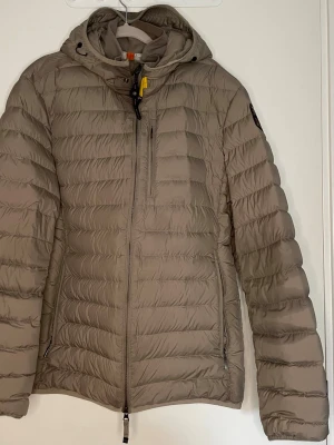 Parajumpers super lightweight dunjacka  - Parajumpers super lightweight dunjacka i färgen beige (finns ej längre i sortiment).  Nypris: 5600kr Jättebra och lätt jacka att använda både under vår, höst och (vinter med en hoodie under). Stilren design som inte sticker ut allt för mycket.  Modellen är väldigt liten i storlek, den passar en person som ligger någonstans mellan L & XL.  Jackan är hel, inga skador men däremot lite tråkiga fläckar som syns tydligt på bilderna med studioljus. Rimliga bud mottages! Hör av dig vid frågor. MVH
