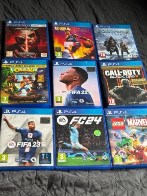 9 PS4-spel: FIFA, NBA, Crash m.fl. - Samling med 9 PlayStation 4-spel: Tekken 7, NBA 2K23, God of War, Crash Bandicoot N. Sane Trilogy, FIFA 22, Call of Duty Black Ops III, FIFA 23, EA Sports FC 24 och LEGO Marvel Super Heroes. Alla i blå plastfodral med originalomslag. Alla spel funkar och är väldigt roliga att spela.