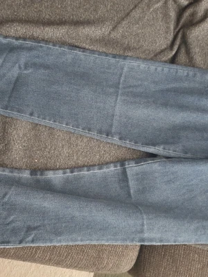 Mörkblå skinny jeans - Säljer ett par mörkblå skinny jeans med smal passform och klassisk femficksdesign. Jeansen har en enkel look utan slitningar eller dekorationer och är perfekta till vardagsstilen. Materialet känns mjukt och stretchigt för extra komfort.