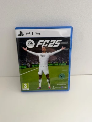 EA Sports FC 25 till PS5 - Säljer spelet EA Sports FC 25 till PlayStation 5. Spelet kommer i ett blått plastfodral med omslag som visar en fotbollsspelare på en grön fotbollsplan. Perfekt för dig som gillar fotbollsspel och vill spela på din PS5. Använd men i mycket gott skick