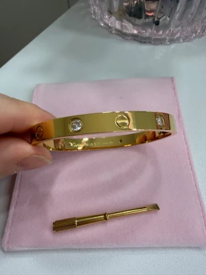Love armband  - Ett stilrent och tidlöst armband tillverkat av rostfritt stål och pläterat med 18K guld. Den eleganta designen gör det till ett perfekt basarmband som enkelt kan matchas med alla dina favoritaccessoarer. Bär det ensamt för en minimalistisk look eller kombinera det med andra armband för en personlig stil.  ✨ Rostfritt stål ✨ 18K guldplätering ✨ Stämplat ✨ Tidlös och lättmatchad design ✨ Finns i storlek 18 cm ✨ Passar både vardag och fest Kolla bifogade bilder😉
