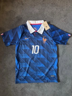 Frankrike 26/27 VM Hemma Mbappe 10 - Tröjan är helt ny med tagg kvar och i perfekt skick. Storlek S. Perfekt för dig som är Frankrike- eller Mbappé-supporter, samlar på fotbollströjor eller vill ha en snygg tröja till träning och vardag. frågor är det bara att skicka ett meddelande.