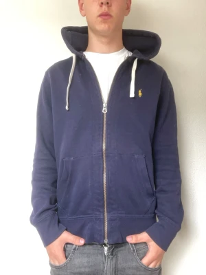 Marinblå hoodie från Polo Ralph Lauren - Modellen är 178cm och väger cirka 70kg. Den är storlek medium men passar som en Small/medium. Hör gärna av er vid frågor eller intresse!