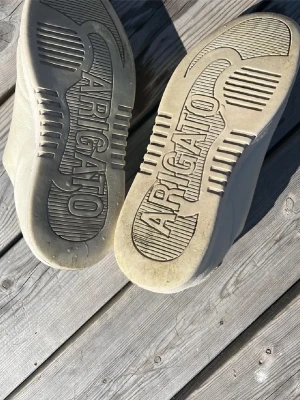 Vita sneakers från Axel Arigato - Stilrena vita sneakers från Axel Arigato i mjukt läder. Klassisk låg modell med diskret design och präglad logga på sulan. Perfekta för dig som gillar minimalistisk och clean stil.