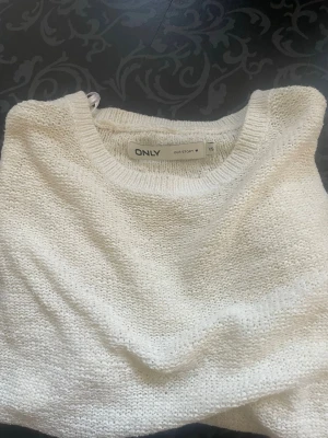 Vit stickad tröja från ONLY - Säljer en enkel och snygg vit stickad tröja från ONLY i storlek XS. Tröjan har rund halsringning och är gjord i ett mjukt, tunt stickat material. Perfekt att matcha med jeans eller kjol för en clean look.