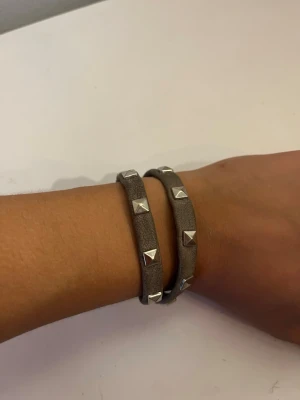 Grått/beige läderarmband med nitar - Läderarmband med nitar på från märket Mint i bra skick. Går även att använda som halsband/chocker🙂 