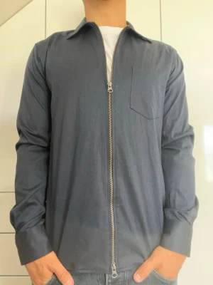 Mörkblå overshirt från John Henric - Mörkblå overshirten från John Henric i 100% bomull. Strl 38/ S. Inga defekter. Modellen är 178 cm och väger 77 kg. Hör gärna av dig vid frågor!