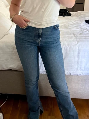 Blå raka jeans  - Säljer ett par klassiska blå jeans med hög midja. Jeansen har en snygg tvätt och raka ben som går ut lite nedtill, samt en slits nertill. Pris kan alltid diskuteras!🥰 Dessa är Carlings egna märke.