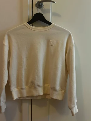 Beige sweatshirt från all in eqestrian  - Säljer en stilren beige sweatshirt från all in eqestrian med deras ikoniska logga på bröstet. Tröjan har rund halsringning, ribbade muddar. Perfekt för en clean och avslappnad look.
