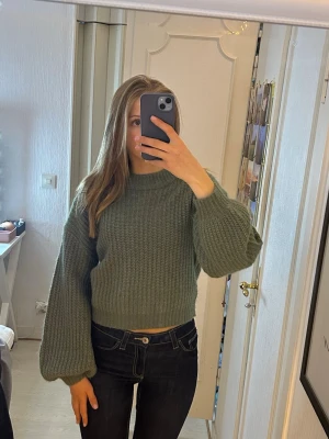Grön stickad tröja - En otroligt fin grön flätstickad tröja som är lite croppad och större/puffig i ärmarna! Väldigt skönt material och älskar färgen!!🥰den är från Vila och är endast använd en gång. 