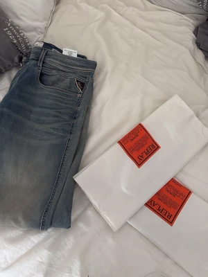 Replay Hyperflex jeans - Säljer ett par Replay Hyperflex jeans i blå tvätt. Klassisk femficksmodell med stretchigt material för extra komfort. Snygg passform och diskreta detaljer, perfekta för en trendig och avslappnad look. Storleken var inte för mig så säljer direkt i samma fraktpåse. Köpt från Boozt