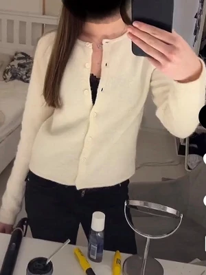 Knitted cardigan från Gina  - Säljer en krämvit kofta med rund hals och knäppning framtill. Koftan har långa ärmar och en mjuk, lite fluffig struktur. Enkel och stilren design som passar perfekt till jeans eller kjol.