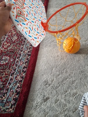 Mini basketkorg med boll DUNK IT - Rolig mini basketkorg med färgglad bakplatta och texten 'DUNK IT'. Korgen är orange med gult nät och medföljer en liten orange basketboll. Perfekt för att spela inomhus och enkelt att hänga upp på dörr eller vägg.