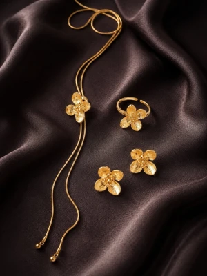 Guldfärgat smyckesset med blommor - Snyggt smyckesset i guldfärg med blommotiv. Setet innehåller ett halsband, ett par örhängen och en justerbar ring, alla med detaljerade blommor i metall. Perfekt för dig som gillar unika accessoarer med naturinspirerad design.