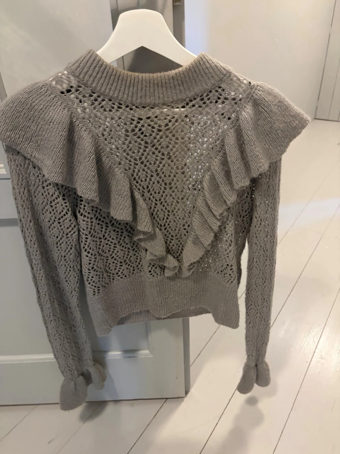 Beige stickad tröja med volanger