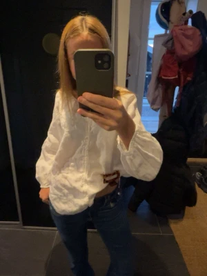 Jätte fin Vit blus - Snygg vit blus med broderade detaljer och fin passform. Blusen har långa ärmar med resår vid ärmslut och en lätt v-ringning framtill. Perfekt att styla med jeans för en avslappnad look. Pris kan diskuteras