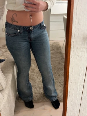 Blå bootcut jeans från True Religion - Säljer ett par blå bootcut jeans från True Religion i storlek 28. Passar mig som har s/m och är 167 cm. Mycket bra skick bortsett från jätte lite slitningar vid hälarna, dock är det inget som syns.
