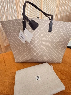 By Malene Birger ”Abi” Printed Tote Bag - Feather - Helt ny med tags kvar enligt bilder.  Färg: Feather/Sand  ”Abi” en rymlig väska passar lika bra för dagligt bruk som för resor. Den har medellånga handtag och ett karbinspänne för enkel stängning, samt en innerficka med dragkedja för värdesaker och en nyckelknippa i läder.  Läderdetaljer  Metalldetaljer  Innerficka med dragkedja  Dustbag medföljer  Mått: Längd 57cm x Höjd 33,5cm x  Bredd 16,5 cm  Nypris 3400kr 