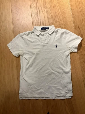 Ralph Lauren Piké S - Säljer en snygg och stilren Ralph lauren piké i vit färg! Otroligt snygg och passar bra under sommaren! Inga defekter, hör av vid fler frågor!!!