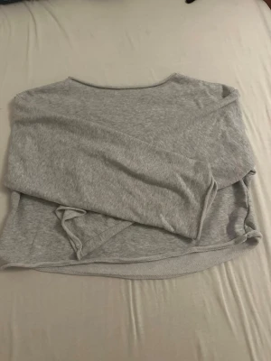 Ljusgrå basic oversized långärmad tröja - En enkel och mjuk ljusgrå översized långärmad tröja i tunt material. Tröjan har rund halsringning och rak passform, perfekt för en avslappnad stil. Passar bra att matcha med jeans eller leggings.  Också bra för lager över lager