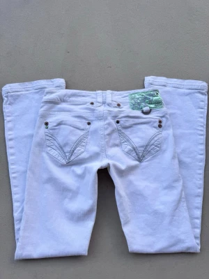 vita lågmidjade bootcut jeans  - de perfekta vita jeansen storlek 34 passar även xs/s då de är lite stretchiga  jättefint skick små mini fläckar som jag upptäckte när jag tog bilder men som annars ej är synliga på de två sista bilderna  midja 36 innerben 76,5 