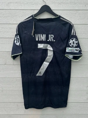 Vinicius Junior Real Madrid Fotbollströja - Säljer en Real Madrid fotbollströja med Vini JR 7 på ryggen som är helt ny med prislapp!