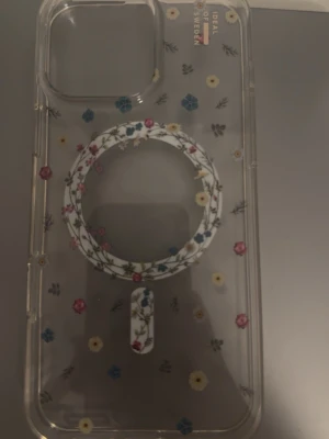 Blommigt mobilskal från iDeal of Sweden - Ett genomskinligt mobilskal för iPhone 16 PRO Max,  från iDeal of Sweden med MagSafe-kompatibilitet. Skalet har färgglada små blommor. Perfekt för dig som vill ha en snygg och unik look på mobilen. Helt ny och oanvänd. 