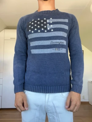 Mörkblå stickad tröja  - Mörkblå tröja från Lexington i Strl S. Det är hål i armhålan på både vänster och höger sida ( se bild 3 och 4). Tröjan är tillverkad i 100% bomull. Modellen är 178 cm och väger 77 kg. Hör gärna av dig vid frågor!
