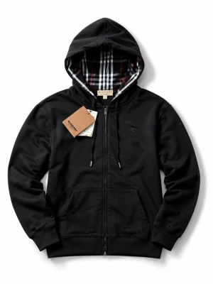 Svart hoodie med dragkedja - Snygg svart hoodie med dragkedja och klassiskt rutigt foder i huvan. Hoodien har fickor framtill, justerbara snören i huvan och diskret logga på bröstet. Perfekt för dig som gillar stilrena och exklusiva plagg.
